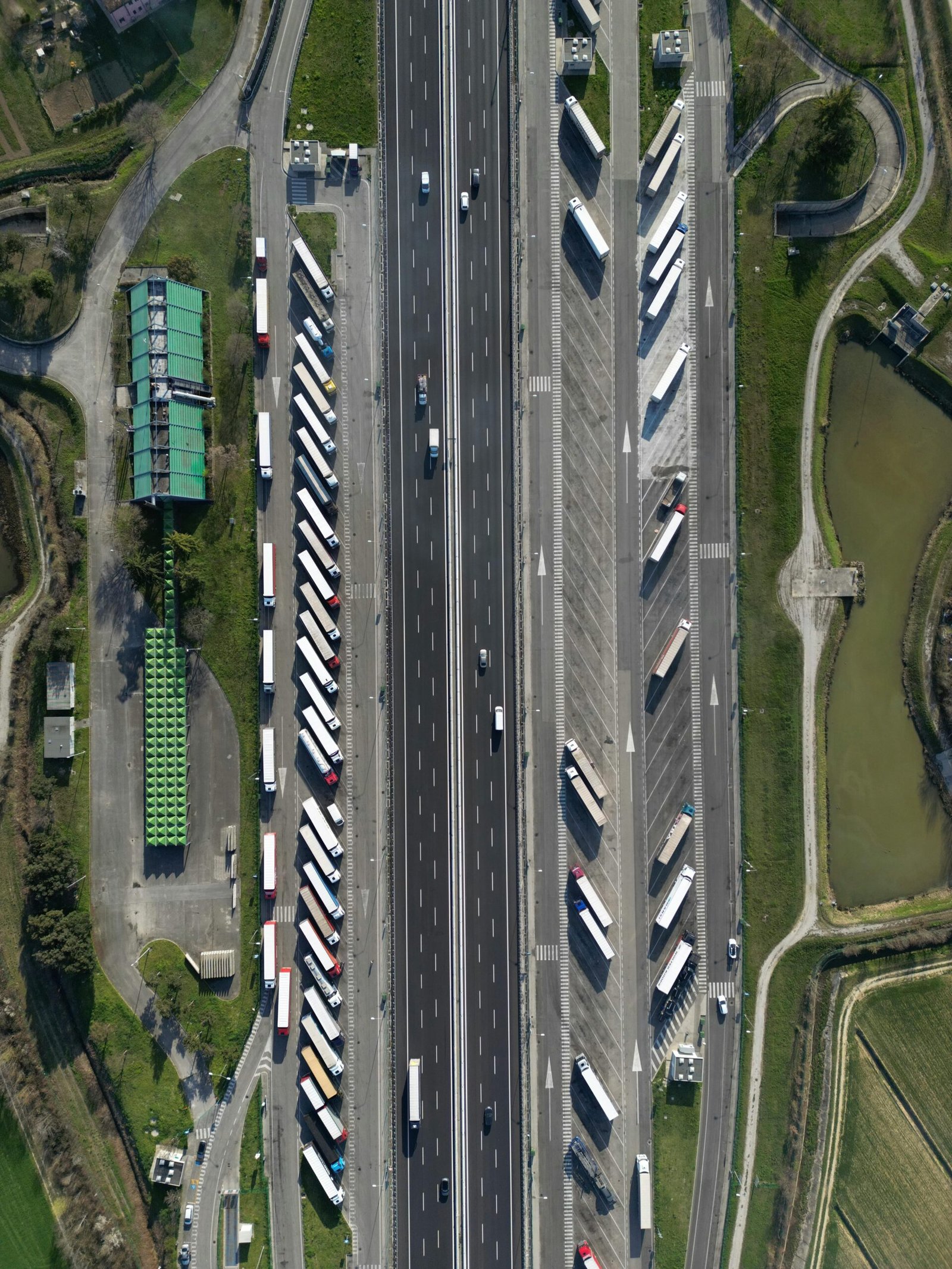 Highway traffic captured from above showcasing trucks and parked vehicles in Roncade, Italy.